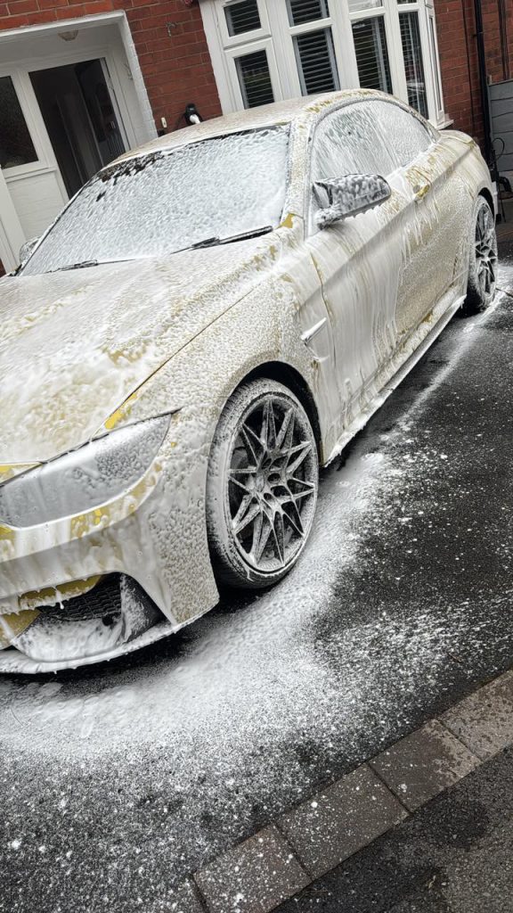 Car covered in snow foam cleaning product