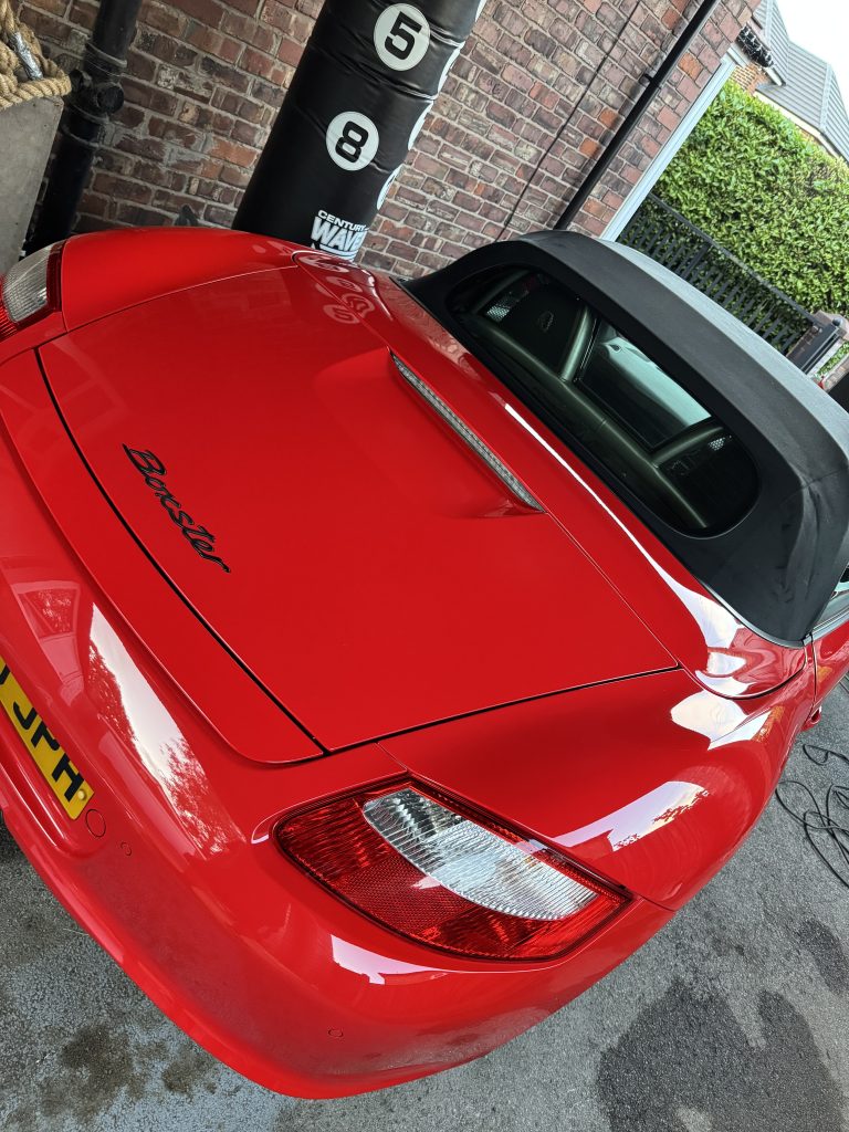 Red Porsche with black soft top roof